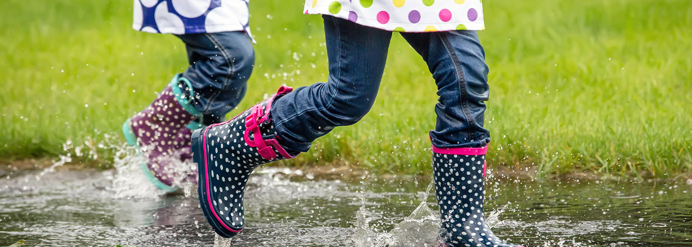 PuddleSplashing Kids jumping in a puddle splashing with rain boots